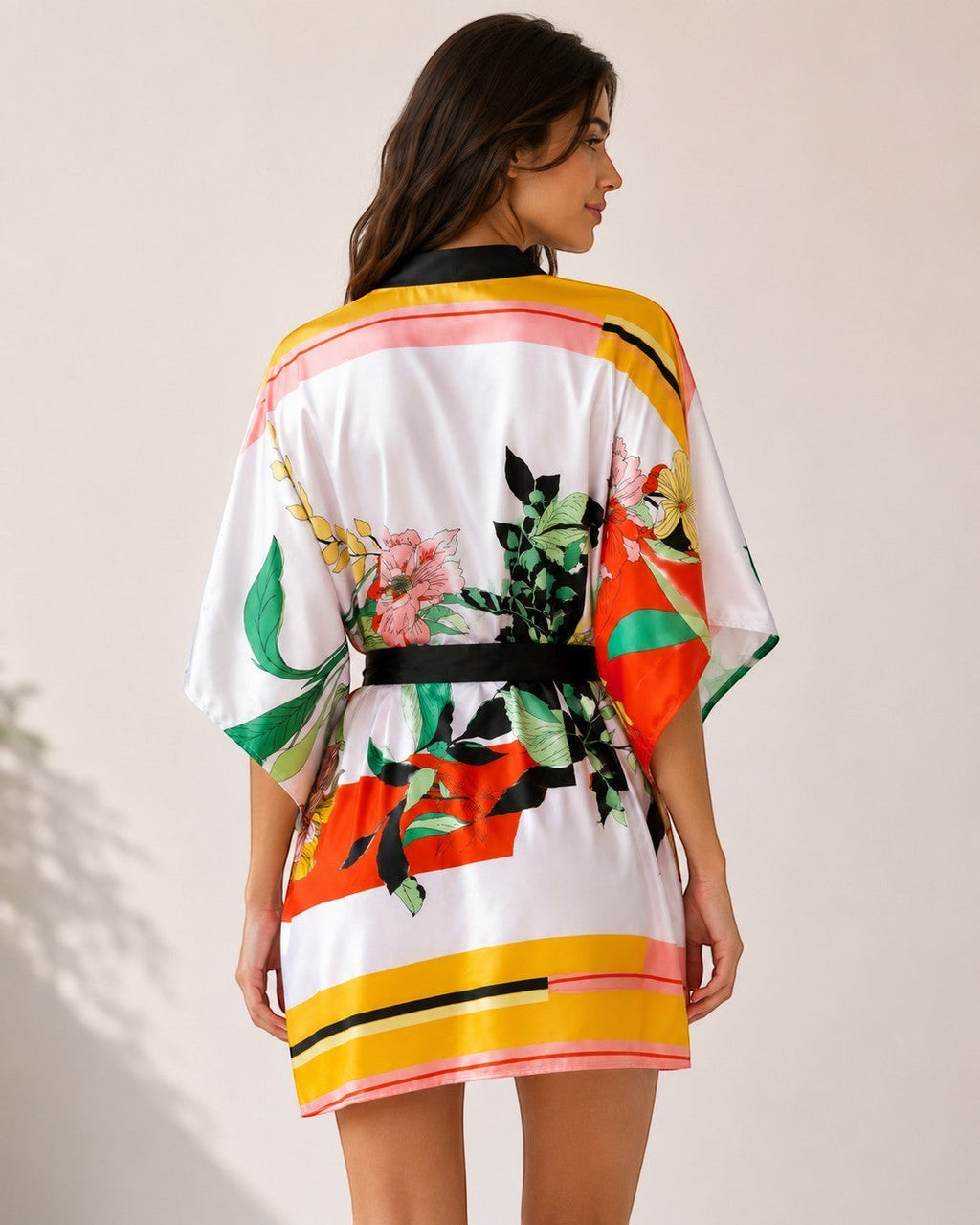Femme portant un peignoir kimono court EMAMOTTO PARIS en tissu fluide à imprimé floral jaune, orange et vert