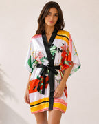 Modèle portant un peignoir kimono court EMAMOTTO PARIS en tissu fluide à imprimé floral coloré avec bordures noires
