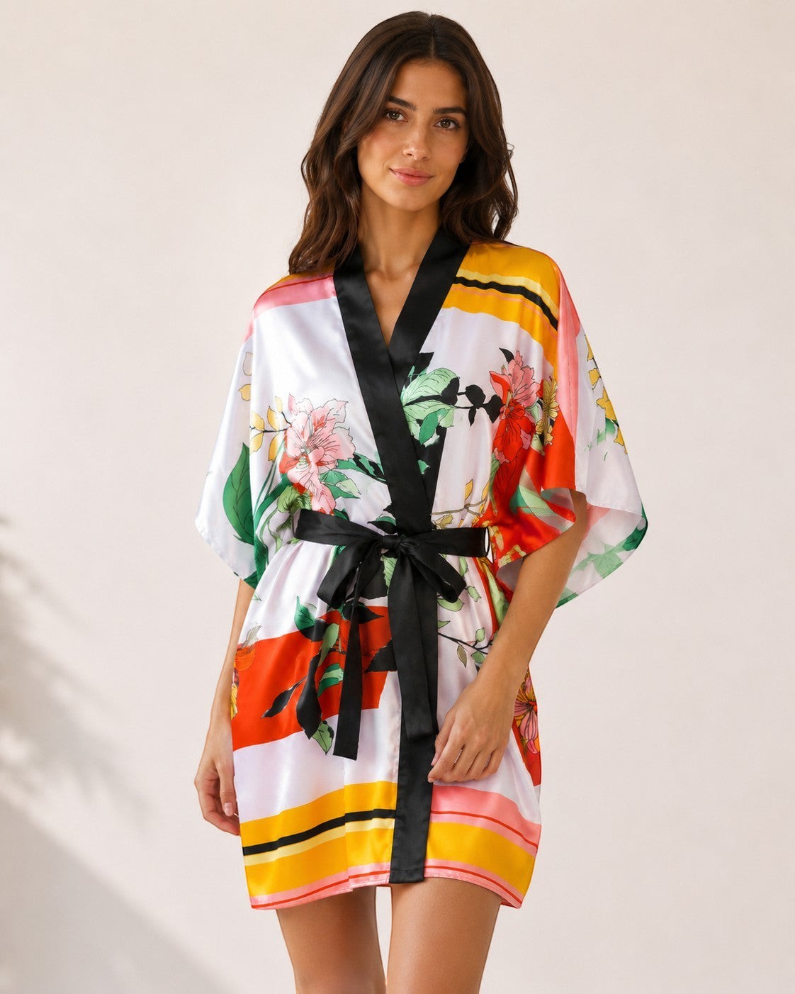 Modèle portant un peignoir kimono court EMAMOTTO PARIS en tissu fluide à imprimé floral coloré avec bordures noires